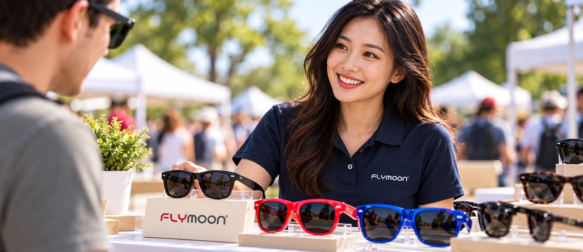 Promotional scene with colorful sunglasses, a FLYMOON display and a model in a branded polo